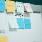 Close-up of a whiteboard with colorful sticky notes for task organization and planning.